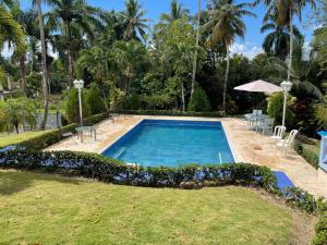 a swimming pool in a yard with blue flowers at Tropical Landhouse in Sánchez