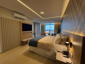 a hotel room with a bed and a television at Hotel London Santarem in Santarém