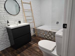a bathroom with a sink and a toilet and a mirror at City Living in New Plymouth +3 photos