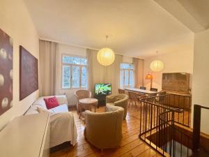 a living room with a couch and chairs and a television at Wienerwaldhof in Irenental