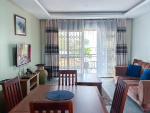 a living room with a table and a couch at NL Josephine's Hotel, Apartment in Kampala