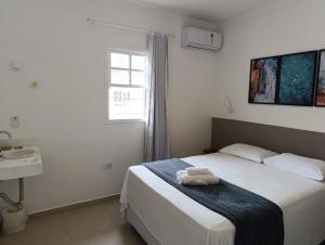 a bedroom with a bed with a towel on it at Pousada Villa Encanto in Juquei
