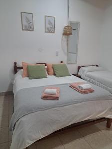 a bedroom with two beds with towels on them at Posada LO DE ELIAS in Tilcara +7 photos