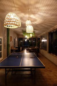 a ping pong table in a room with two chandeliers at Tucan Hostel in Puerto Iguazú