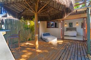 a patio with a bed and a straw umbrella at Villa Giulia Morro Residence in Morro de São Paulo +77 photos