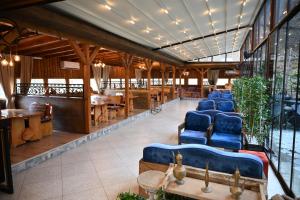 a lobby with blue chairs and tables and windows at Hotel Aventus -Novi Pazar Banja in Novi Pazar