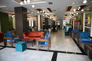 a lobby with a red couch and blue chairs at Hotel Aventus -Novi Pazar Banja in Novi Pazar