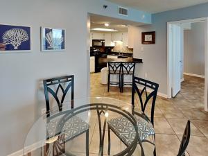 a dining room and kitchen with a glass table and chairs at Phoenix III #3146 in Orange Beach