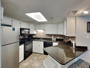 a kitchen with white cabinets and a black counter top at Phoenix III #3146 in Orange Beach +21 photos