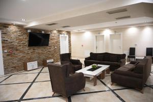 a living room with couches and a tv on a brick wall at Hotel Aventus -Novi Pazar Banja in Novi Pazar