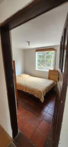 a bedroom with a bed in a room with a window at Finca El Recuerdo in Guatavita