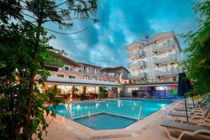 a hotel with a swimming pool in front of a building at Side Orientt Apartments in Side