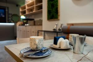 a table with two cups and plates and utensils at Boutique Hotel Prokopovka 34 in Pilsen