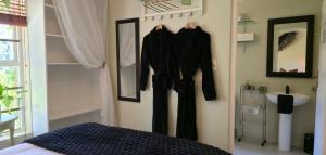 a bedroom with a bed and a sink and a mirror at SAGE Cottage Bloubergstrand in Cape Town