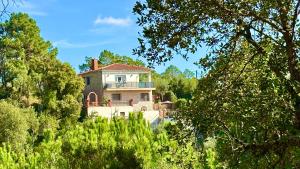 a house on top of a hill with trees at Villa Lloret De Mar in Lloret de Mar