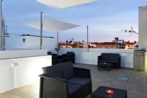 a rooftop patio with furniture and a view of the city at Hostal Boutique El Patio Lepe in Lepe