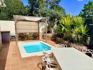a swimming pool in a backyard with a table and chairs at Villa Lloret De Mar in Lloret de Mar
