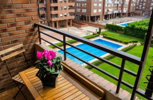a balcony with a plant on a bench and a pool at Apto La Estambrera I I Wifi y Aire Acondicionado in Logroño