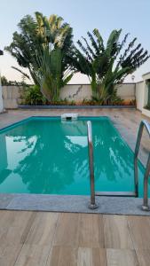 a swimming pool with a chair in front of a house at Noble Grand Villa in Mahabalipuram