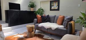 a living room with a couch with pillows on it at SAGE Cottage Bloubergstrand in Cape Town