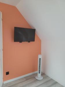 a flat screen tv on a wall in a room at Lacavee in Le Tréport
