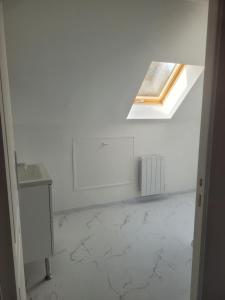 a white room with a skylight and a table at Lacavee in Le Tréport