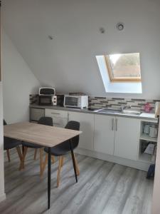 a kitchen with a table and chairs in a room at Lacavee in Le Tréport