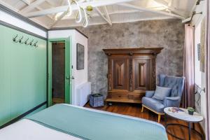 a bedroom with a bed and a chair and a table at Larimis House in Loutraki
