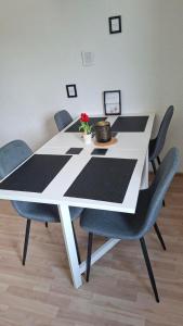 a white table with chairs and a flower on it at Gutliegende Wohnung in Maybach +2 photos