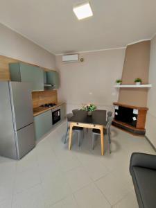 a kitchen and dining room with a table and a refrigerator at Il Rovo Casa vacanze in Cava deʼ Tirreni