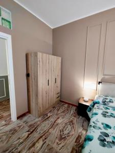 a bedroom with a bed and a wooden door at Il Rovo Casa vacanze in Cava deʼ Tirreni