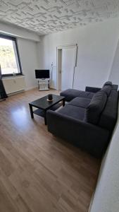 a living room with a black couch and a table at Gutliegende Wohnung in Maybach