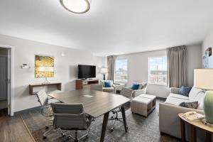 a living room with a table and a couch at Staybridge Suites - Calgary Airport by IHG in Calgary