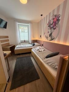 a bedroom with two beds and a window at AMADEA - Cityhotel Salzburg in Salzburg