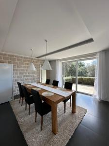 a dining room with a wooden table and chairs at Villa Nika in Bečići