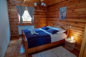a bedroom with a bed in a log cabin at Greenhouse Klara with heated pool in Tršće +49 photos