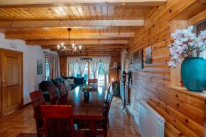 a dining room with a table and chairs at Greenhouse Klara with heated pool in Tršće