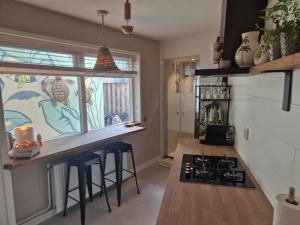 a kitchen with a counter and a stove top oven at Zandvoort Beach Escape 2P in Zandvoort
