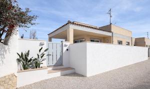 a white house with a white fence in front of it at Sa Tuna - Delta de l'Ebre in Riumar