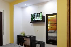 a bedroom with a bed and a tv on a wall at Hostal Boutique El Patio Lepe in Lepe