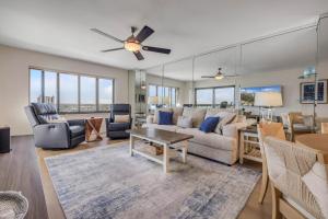 a living room with a couch and a table at Sunrise beach views with top complex amenities and pool access! in Ormond Beach