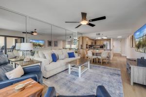 a living room with a couch and a table at Sunrise beach views with top complex amenities and pool access! in Ormond Beach +37 photos