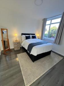 a bedroom with a large bed and a window at Two Bedroom Flat Bristol in Shirehampton