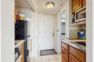 a kitchen with a black refrigerator and a sink at Coastal condo with shared pool beaches shopping in Fort Walton Beach