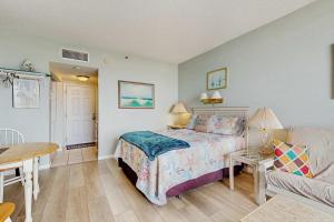 a bedroom with a bed and a table and a couch at Coastal condo with shared pool beaches shopping in Fort Walton Beach
