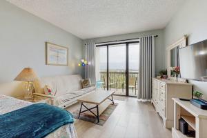 a living room with a bed and a couch and a television at Coastal condo with shared pool beaches shopping in Fort Walton Beach
