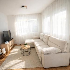 a white living room with a white couch and a tv at Sa Tuna - Delta de l'Ebre in Riumar