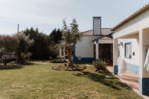 a villa with a garden and a house at NaNa House Ericeira - Yoga & Surf in Santo Isidoro