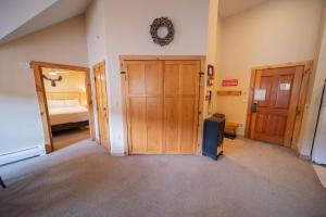 a hallway with two wooden doors and a bedroom at Buffalo Lodge 8411 by SummitCove Lodging in Colorado in Keystone +48 photos