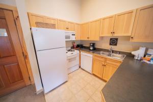 a kitchen with a white refrigerator and a sink at Buffalo Lodge 8411 by SummitCove Lodging in Colorado in Keystone